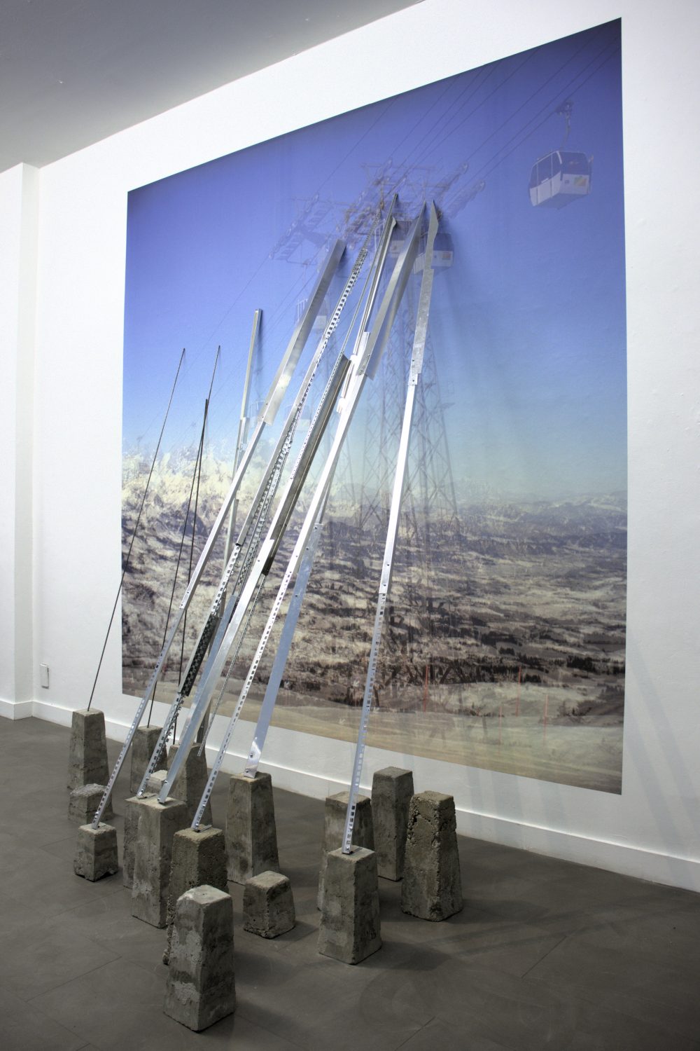 Installation O.T. (Fleckalm, 3.1.2017, 1 min), 2025 digitalisierte analoge Farbfotografie auf Fototapete, 300 x 300 cm, Aluminium und Stahlelemente, Betonsockel (verschiedene Größen), Schrauben, Nägel, Kleber 